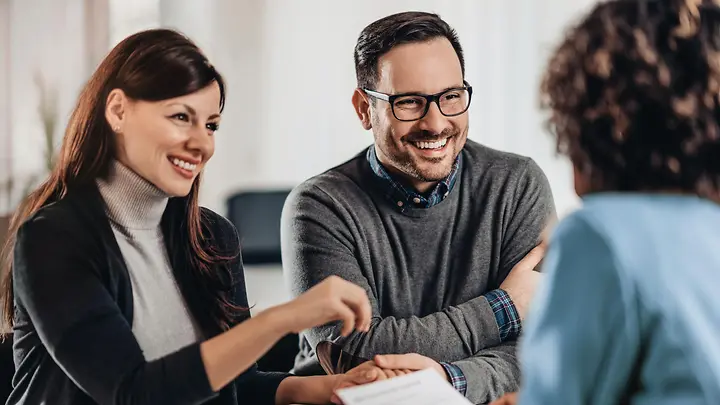 Ein Mann und eine Frau sind in einem Gespräch mit einer anderen Person.