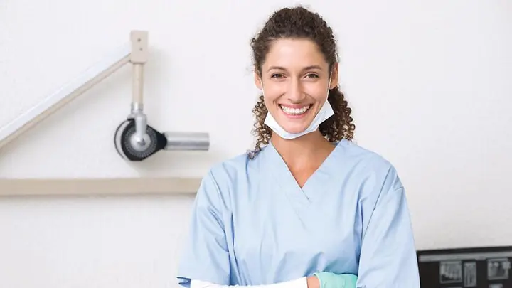 Man sieht eine junge Zahnarzthelferin. 