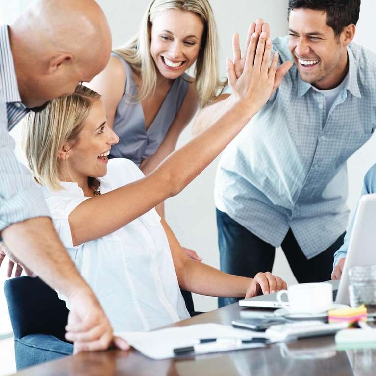 Ein Arbeitsteam ist glücklich und alle freuen sich zusammen.