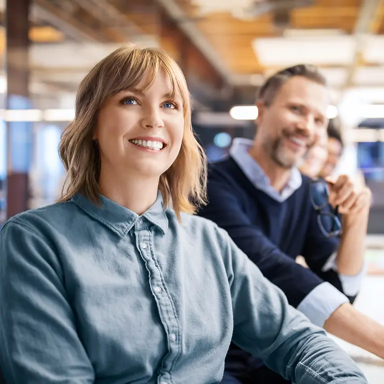 Mitarbeiter lachen in einem Termin - Betriebliche Krankenversicherung